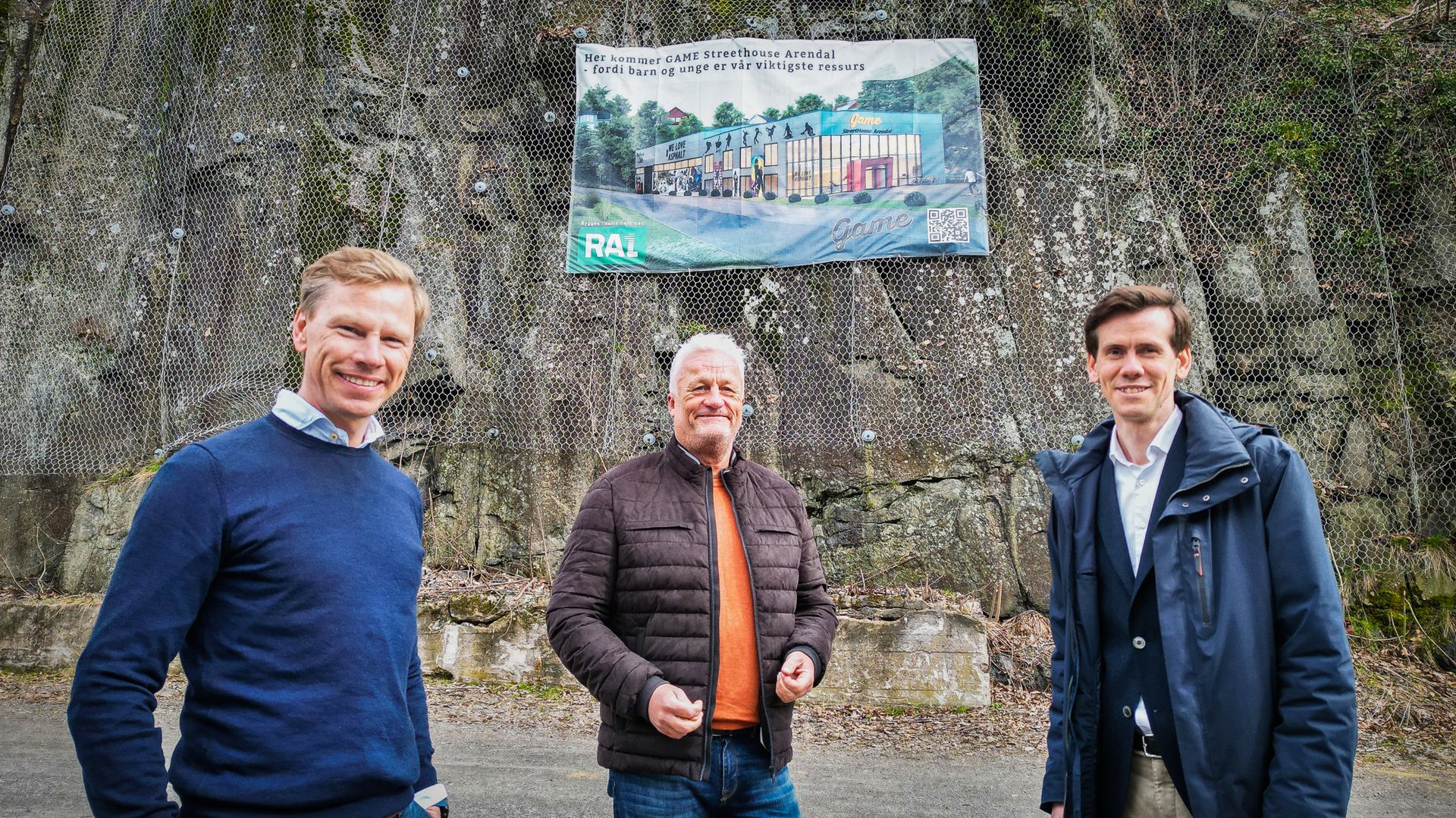Photo of Lars Lislegard-Bækken (COO at Gard) Rolf Josephsen (Leader at Game Norge) and Benjamin Goulding (CEO at Arendals Fossekompani) standing in front of a banner displaying the GAME Streethouse Arendal project.