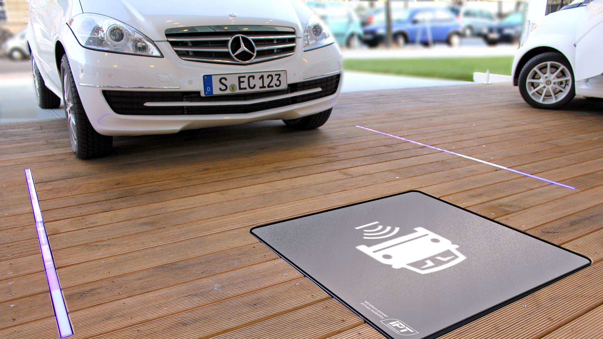 The image shows a white car parked over an inductive charging pad, indicated by a graphic symbol of a car with a charging icon.