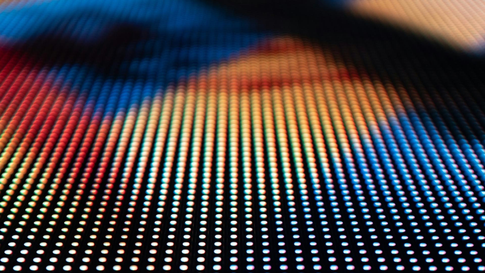 A close-up of a digital screen showing a grid of pixels in various colors, creating an abstract pattern.